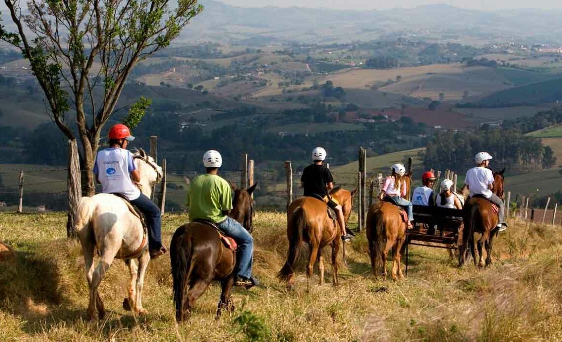 Cavalgada ecológica - grupo de cavaleiros seguem trilha em uma montanha