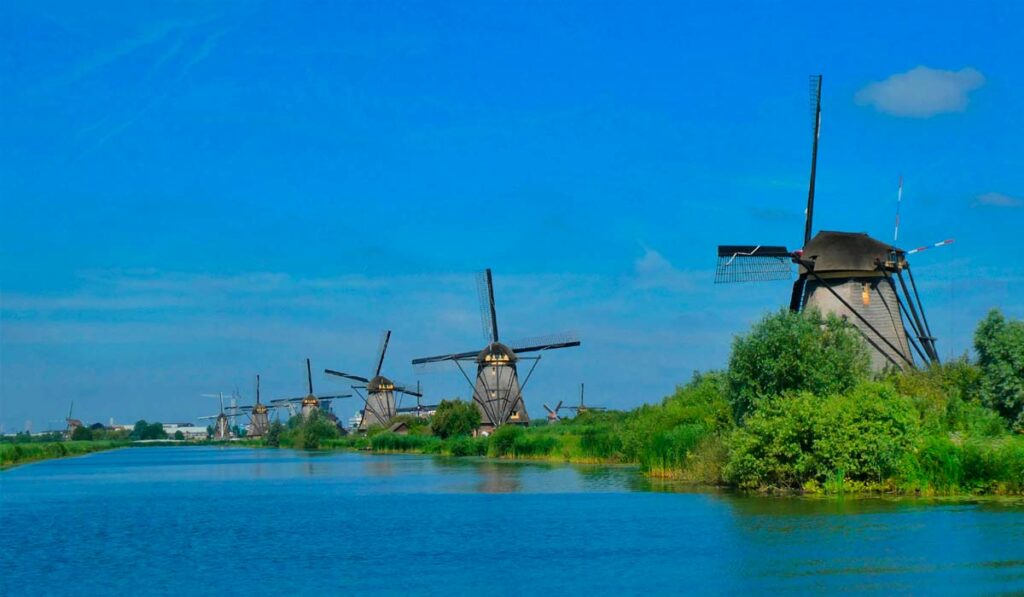 Moinhos à margem de canal na Holanda