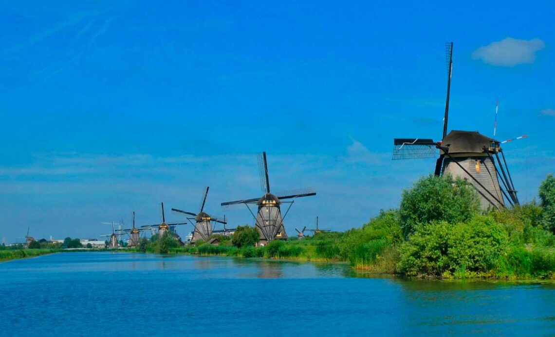 Moinhos à margem de canal na Holanda