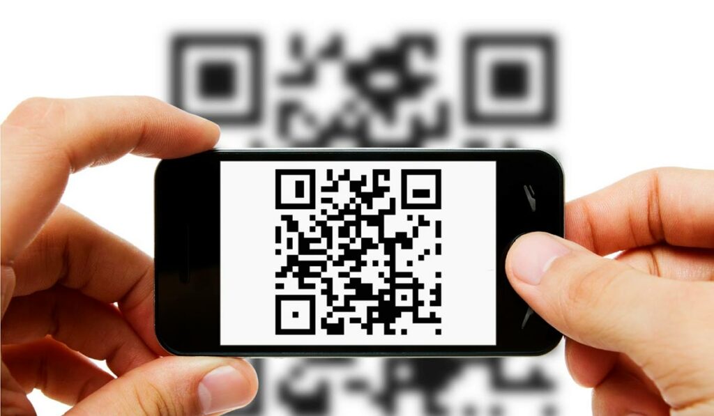 Consumidor com celular mirando num QR Code