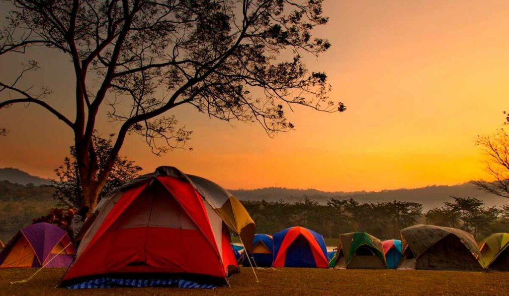 Barracas em área de camping ao entardecer