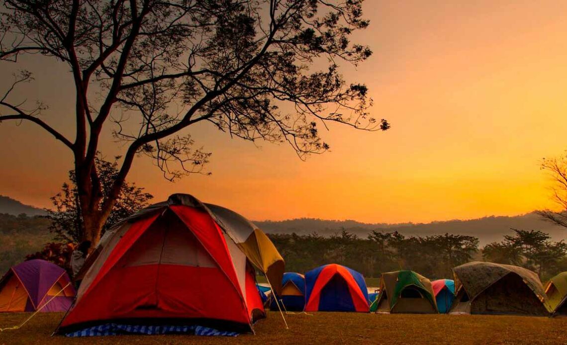 Barracas em área de camping ao entardecer