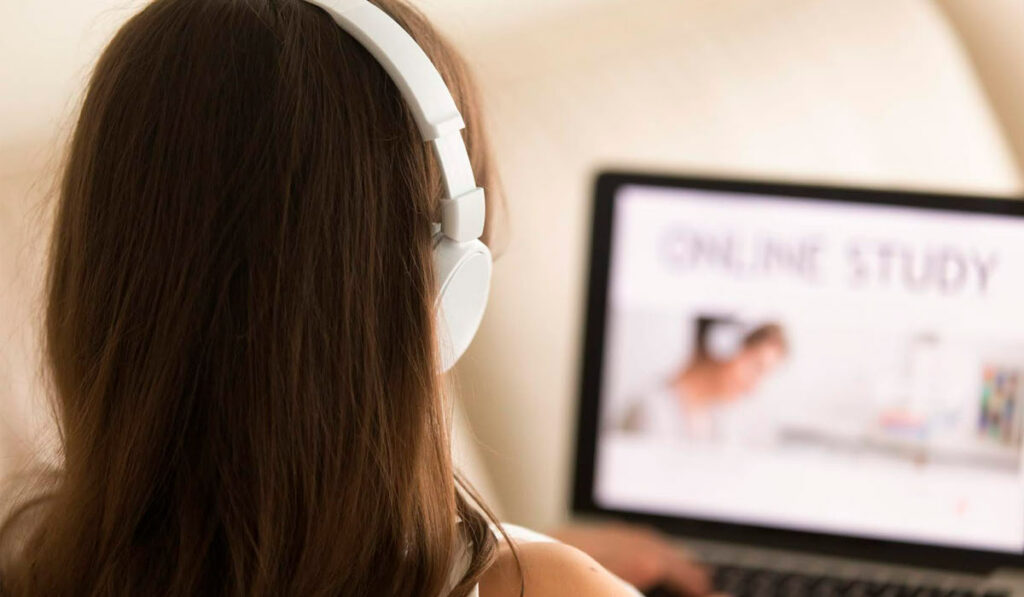 Estudante à frente do laptop em curso online