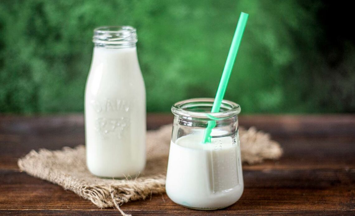 Garrafa e copo de leite sobre a mesa