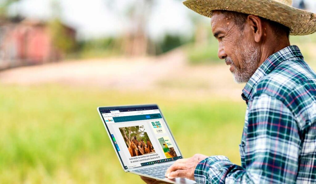 Agricultor com laptop nas mãos acessando a RuraltecTV