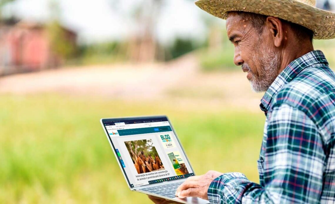 Agricultor com laptop nas mãos acessando a RuraltecTV