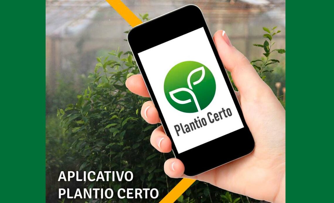 Smartphone com aplicativo Zarc Plantio Certo dentro de uma estufa de horticultura