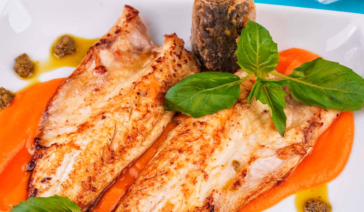 O prato pronto com o filé de peixe passado sobre o pure de abóbora