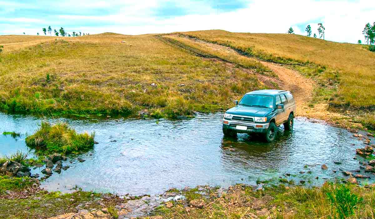 Off road atravessando um regato em área de campo