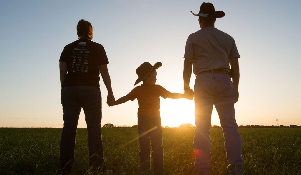 Família rural olhando o horizonte com por sol