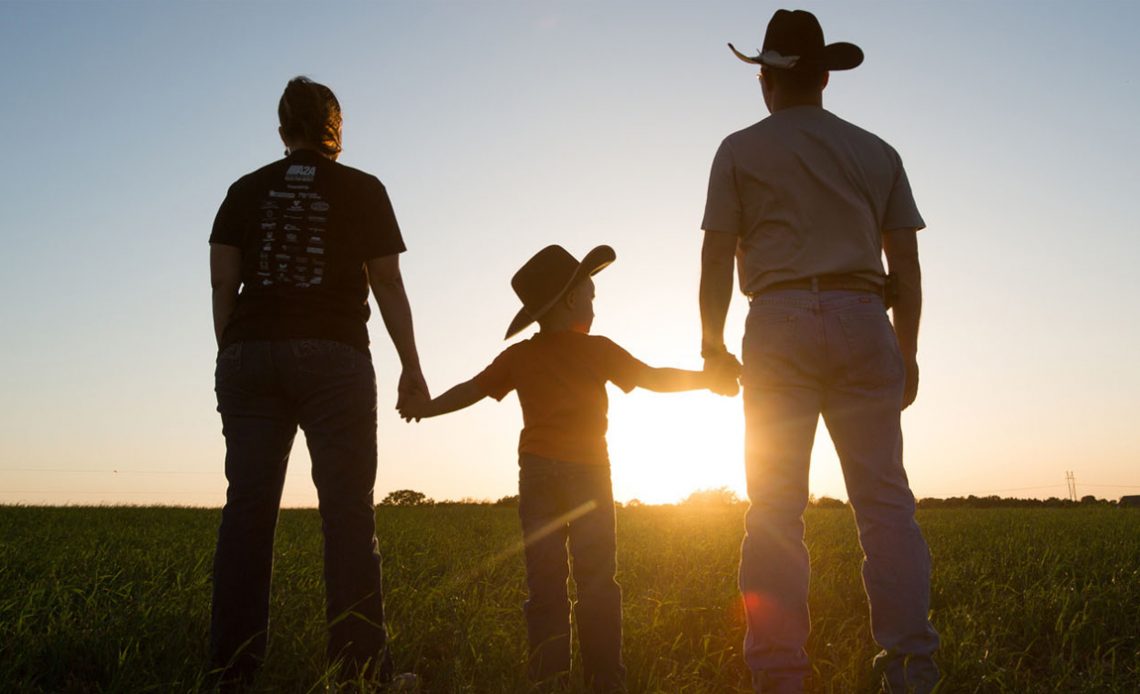 Família rural olhando o horizonte com por sol