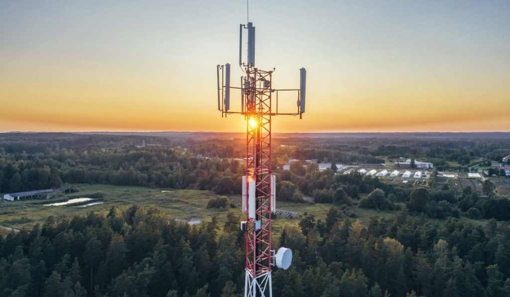 Antena em área rural com sol se pondo ao fundo