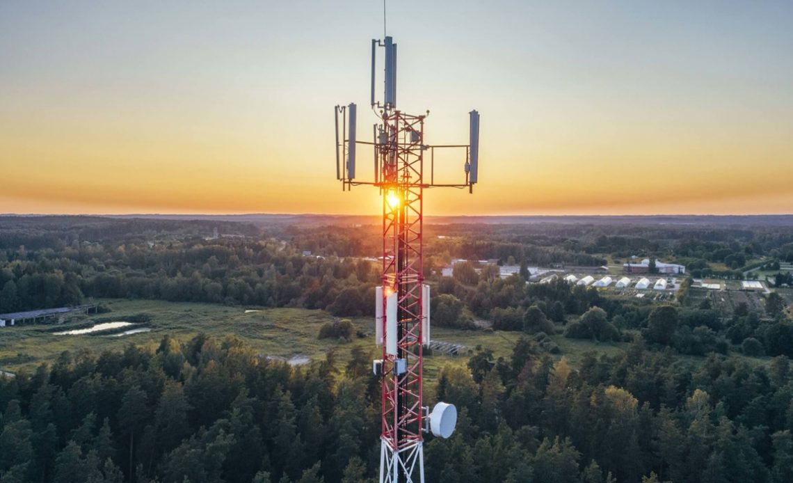 Antena em área rural com sol se pondo ao fundo