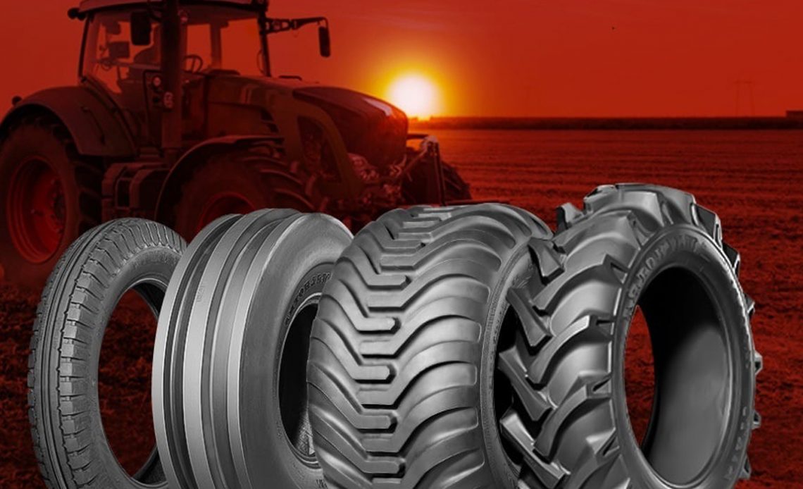 Vários modelos de pneus agrícolas com trator e por do sol ao fundo
