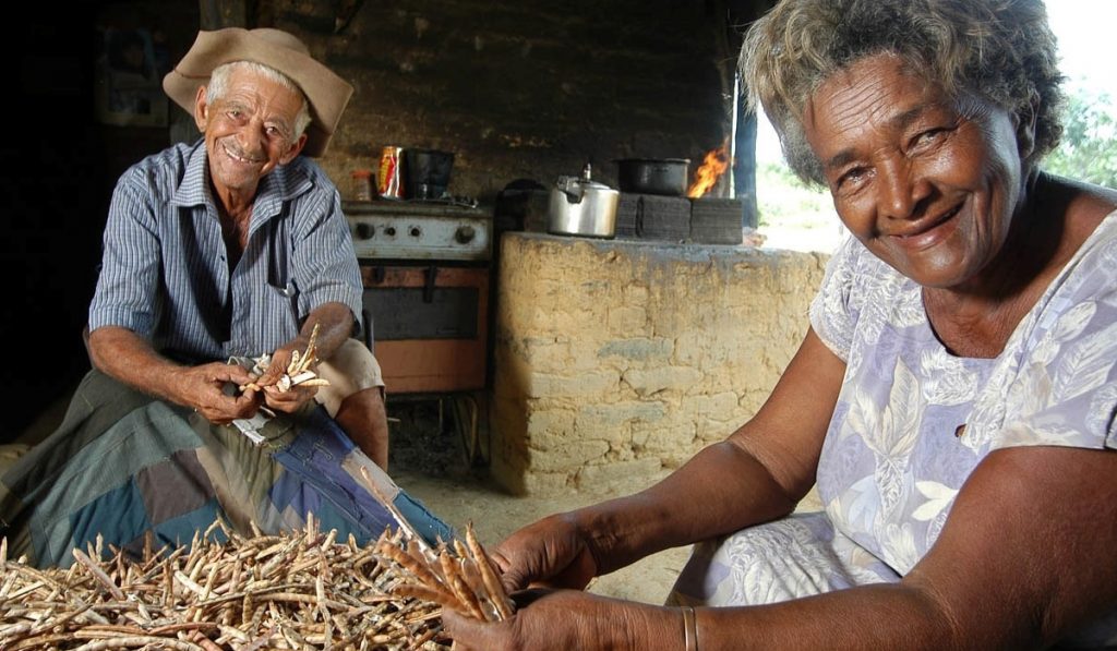 Casal de produtores rurais com o feijão colhido