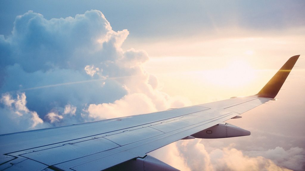 Vistas da cabine de um avião com a asa e o céu ao fundo