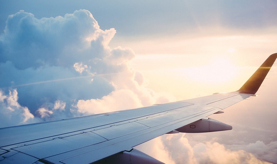 Vistas da cabine de um avião com a asa e o céu ao fundo