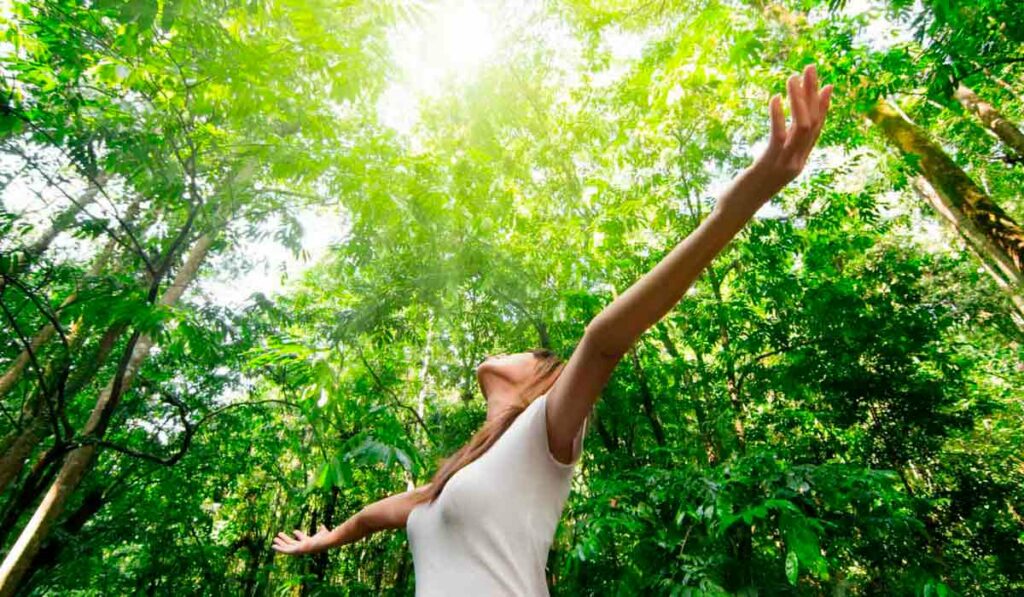 Mulher respirando em contato direto com área verde