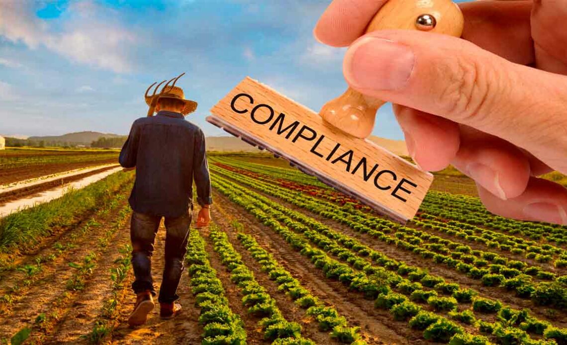 Carimbo com compliance e agricultor na lavoura ao fundo