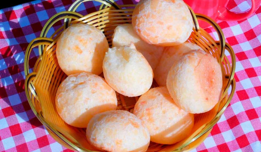 Cesto com pães de queijo sobre a mesa