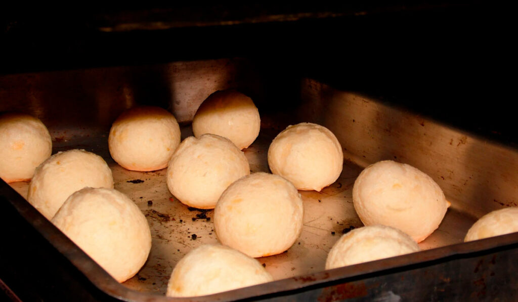 Bandeja de pães de queijo saindo do forno