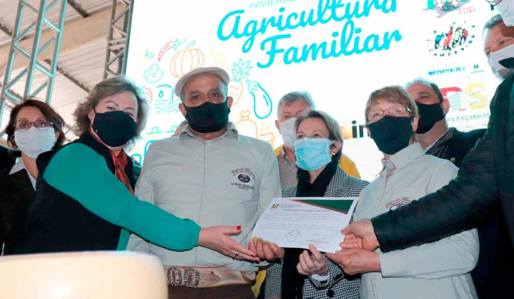 O casal de produtores recebendo o selo arte das mãos da Secretária de Agricultura do Estado e da ministra da agricultura