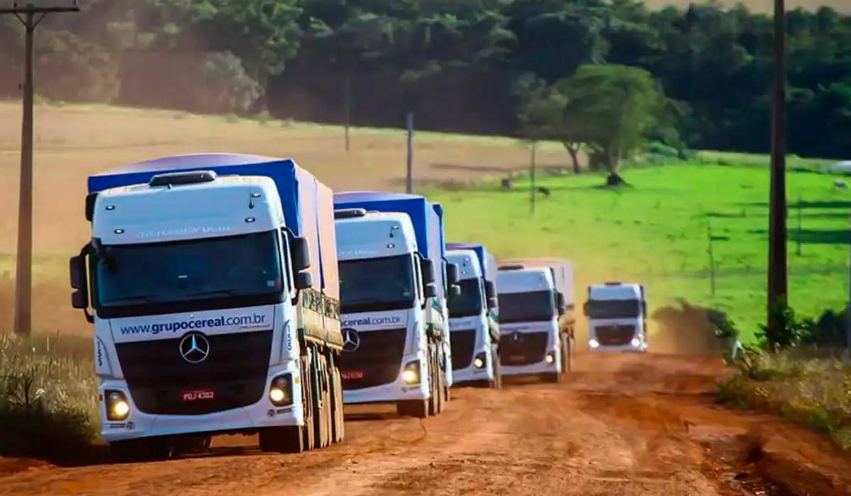 Comboio de caminhões em uma estrada vicinal de terra