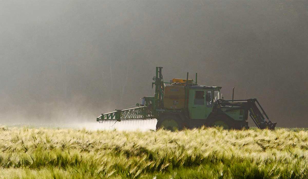 Aplicação mecanizada de pesticida em lavoura europeia