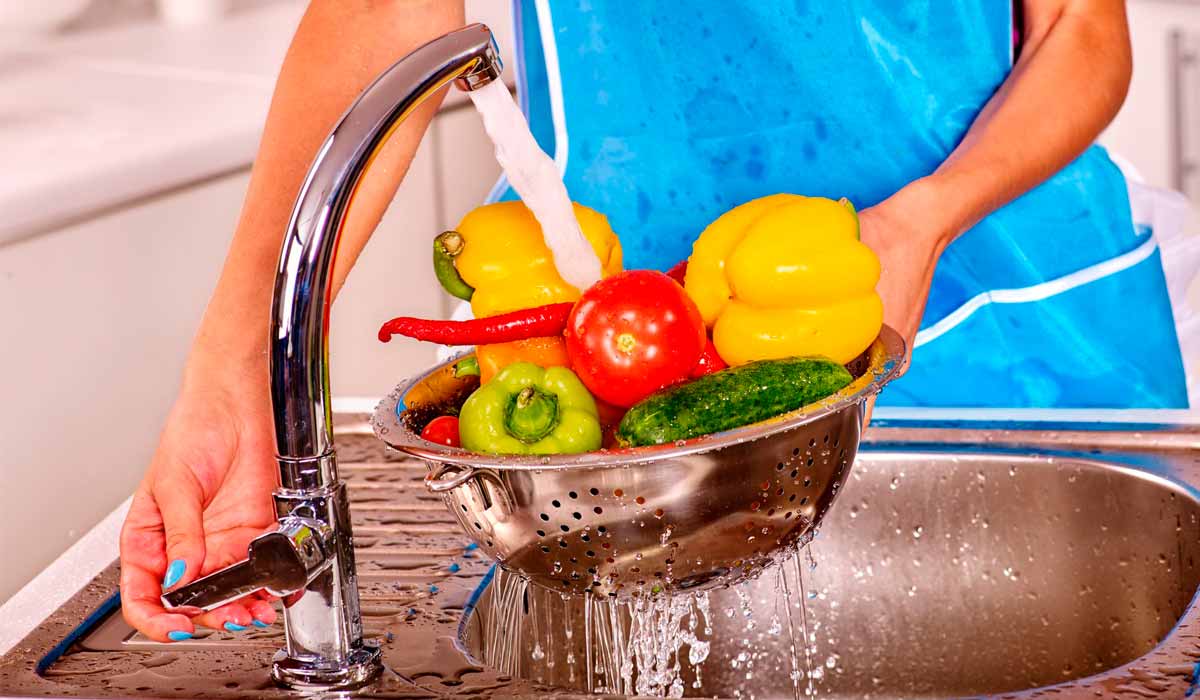 Dona de casa lavando legumes
