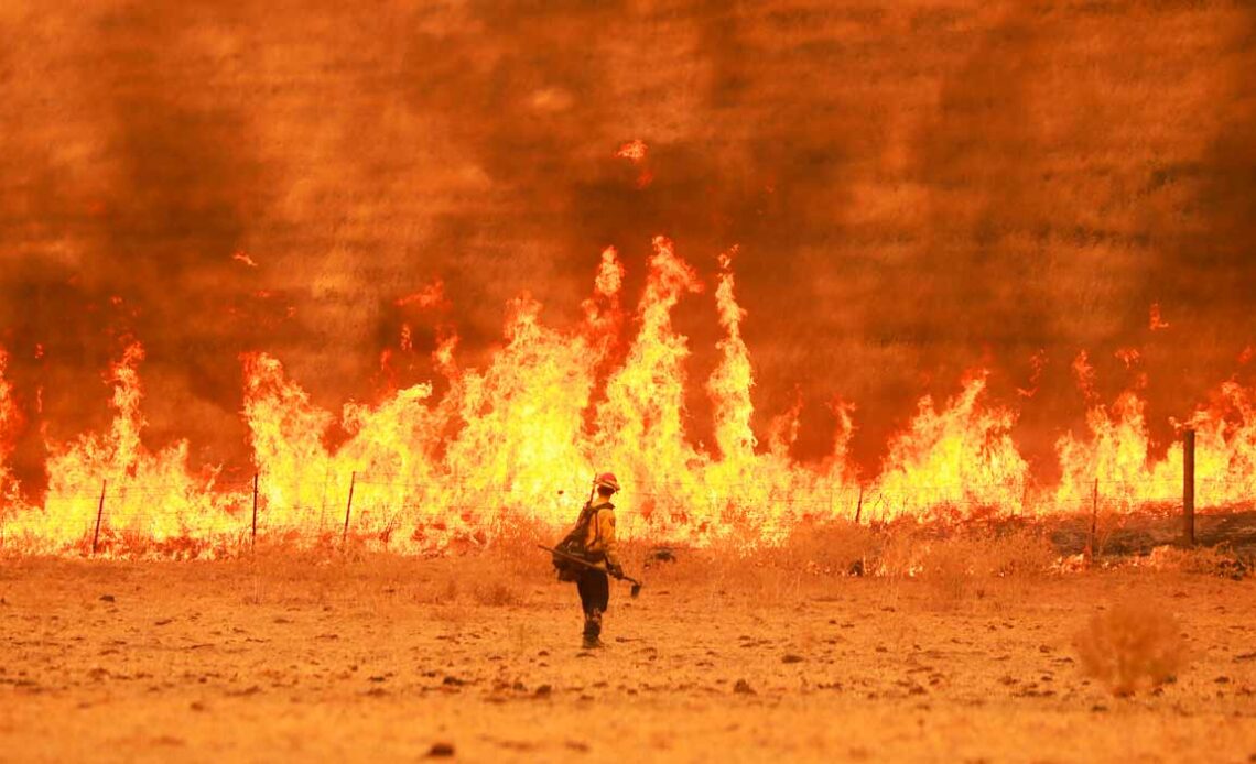 Membro da brigada de incêndio em combate a uma queimada