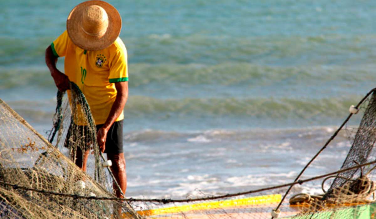 Pescador artesanal preparando sua rede na praia