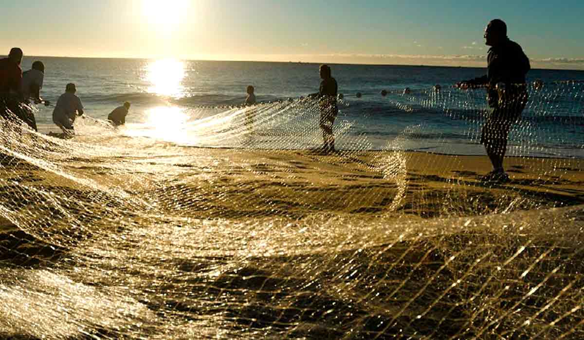 Pescadores puxando a rede na praia