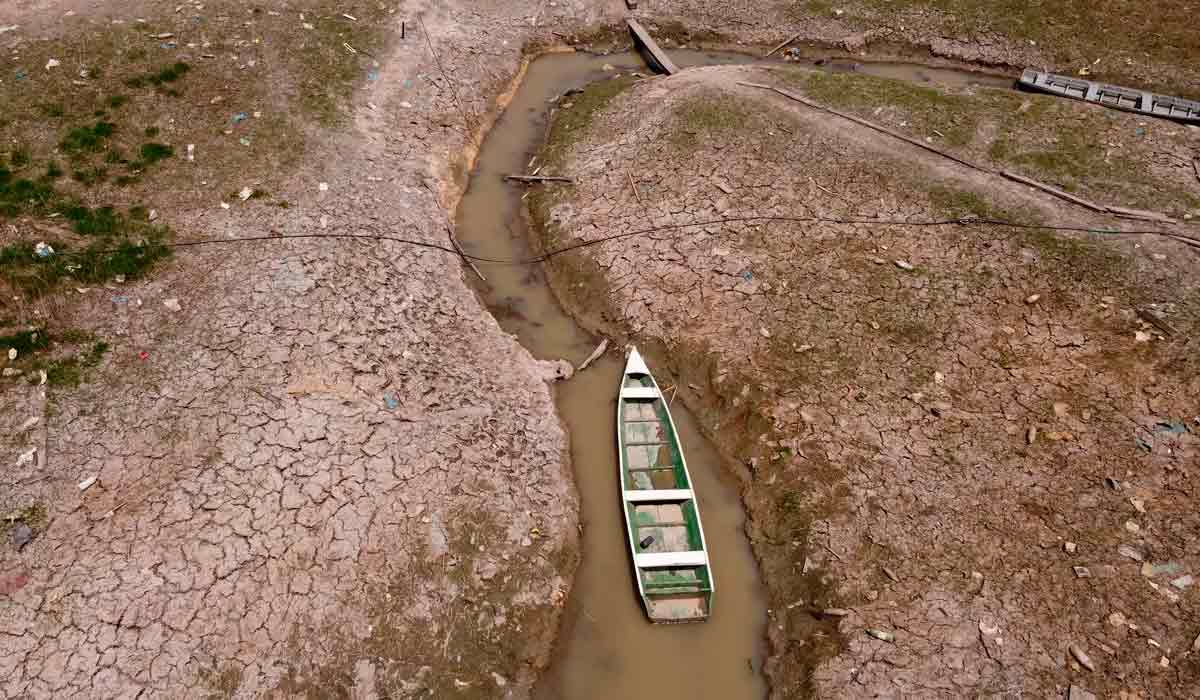 Barco encalhado no que resta de um leito de rio