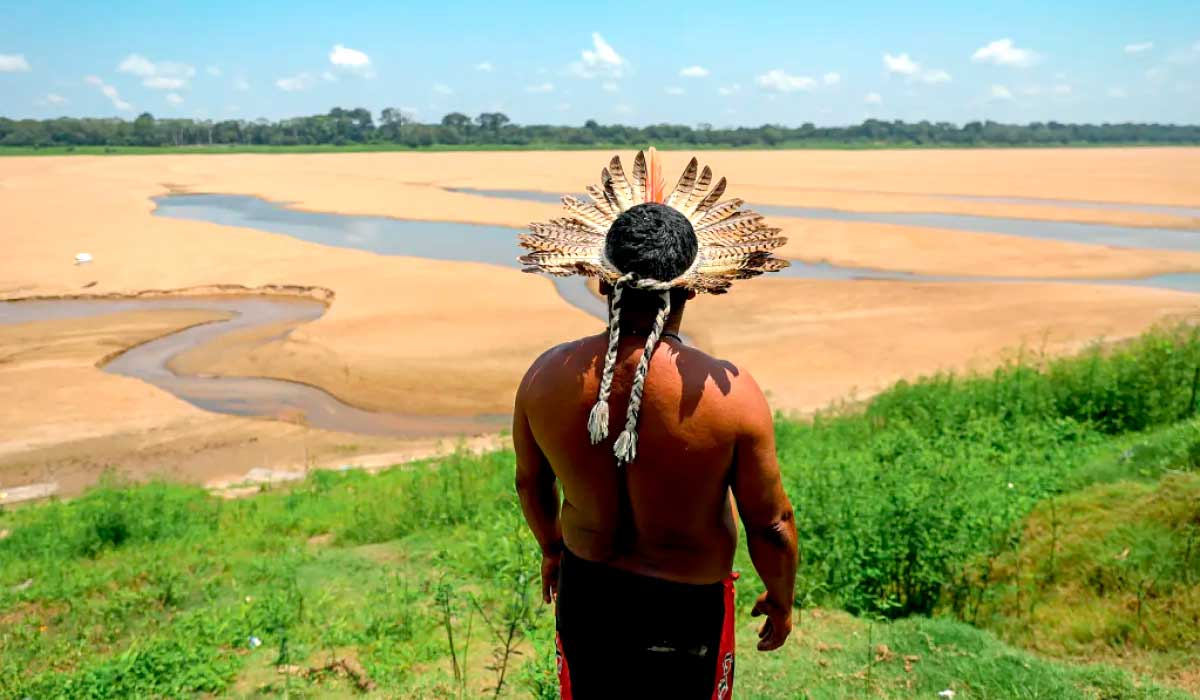 Indígena desolado observando o Rio Negro: volume de água mais baixo desde 1902, quando medição começou a ser feita - Foto: Alex Pazuello/Gov. Amazonas/SECOM
