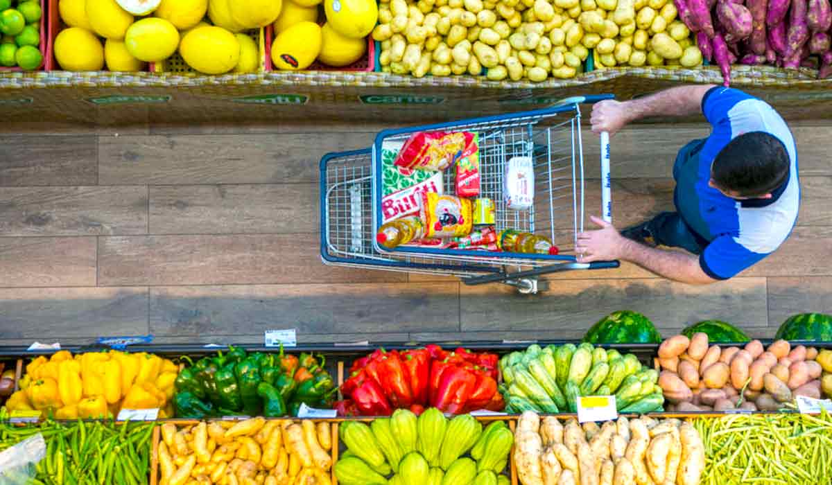 Consumidor no corredor de hortifrutis de um mercado