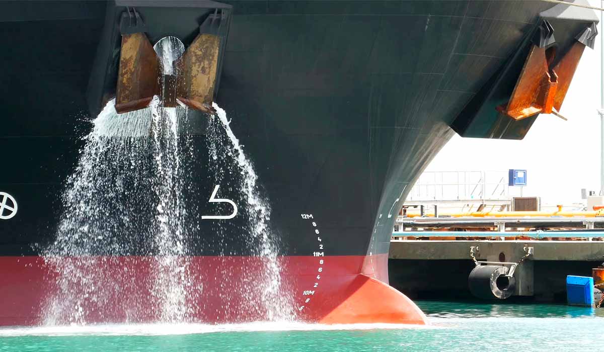 Navio atracado descarregando água de lastro diretamente no ambiente
