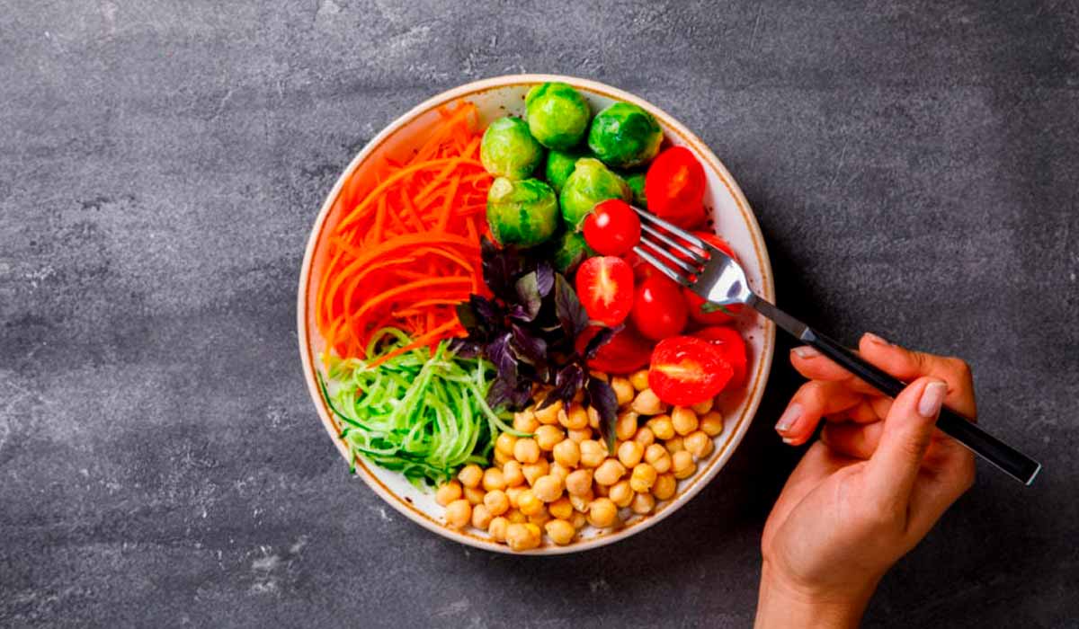 Alimentos vegetais no prato sendo consumidos