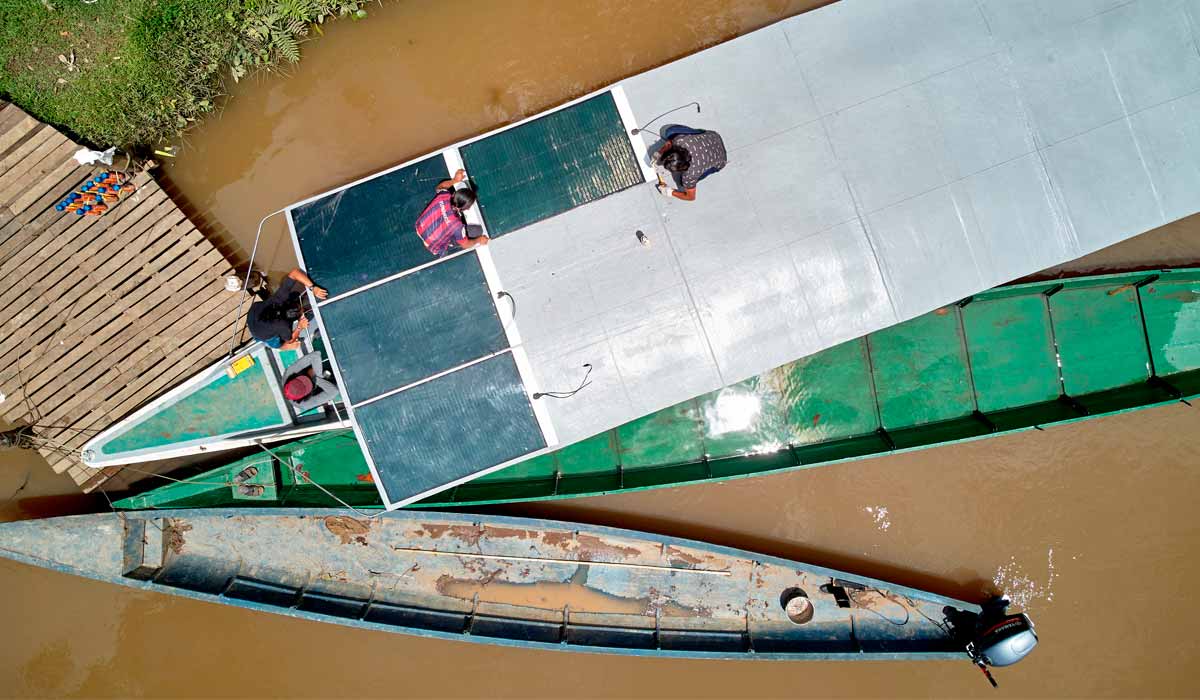 Indígenas instalando painéis solares na embarcação