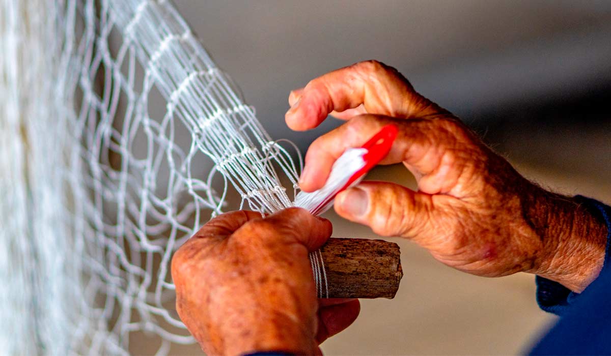 Pescador reparando sua rede