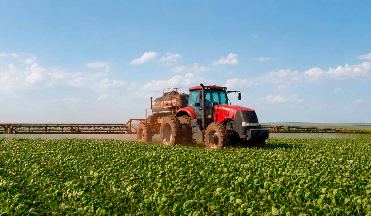 Trator moderno operando em lavoura de soja, ambiente de produção agropecuária